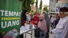 Seorang wanita lanjut usia menerima bantuan uang tunai di masjid Cheng Hoo, Surabaya, Jawa Timur pada Rabu 4 Maret 2026. Ribuan warga Kota Surabaya memadati kawasan Masjid Muhammad Cheng Hoo, Surabaya, Jawa Timur, untuk menerima penyaluran zakat mal. (JUNI KRISWANTO/AFP)