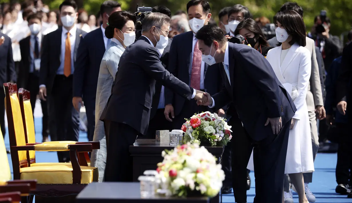 <p>Presiden baru Korea Selatan Yoon Suk-yeol (tengah kanan) berjabat tangan dengan mantan Presiden Moon Jae-in setibanya pada upacara pelantikannya di Majelis Nasional, Seoul, Korea Selatan, Selasa (10/5/2022). (Kim Hong-ji/Pool Photo via AP)</p>