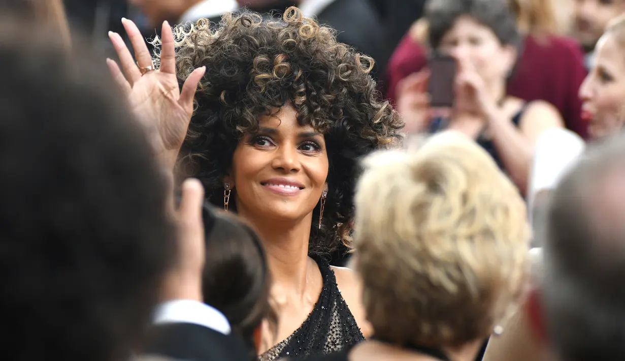 Aktris Halle Berry melambaikan tangan ke arah fans setibanya di ajang penghargaan Oscar 2017 di Dolby Theatre, Los Angeles, Minggu (26/2). Datang sendiri ke Oscar 2017, Halle Berry tampil percaya diri dengan berambut kribo (Photo by Al Powers/Invision/AP)