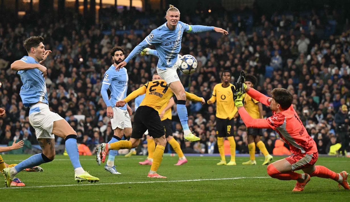 Kiper Dortmund asal Swiss, Gregor Kobel (kanan) menepis tembakan pemain depan Manchester City asal Norwegia, Erling Haaland, dalam pertandingan lanjutan fase liga Liga Champions 2025/2026 antara Manchester City dan Borussia Dortmund di Stadion Etihad, Manchester, Inggris barat laut, pada 5 November 2025 waktu setempat atau Kamis (6/11) dini hari WIB. (Oli SCARFF/AFP)