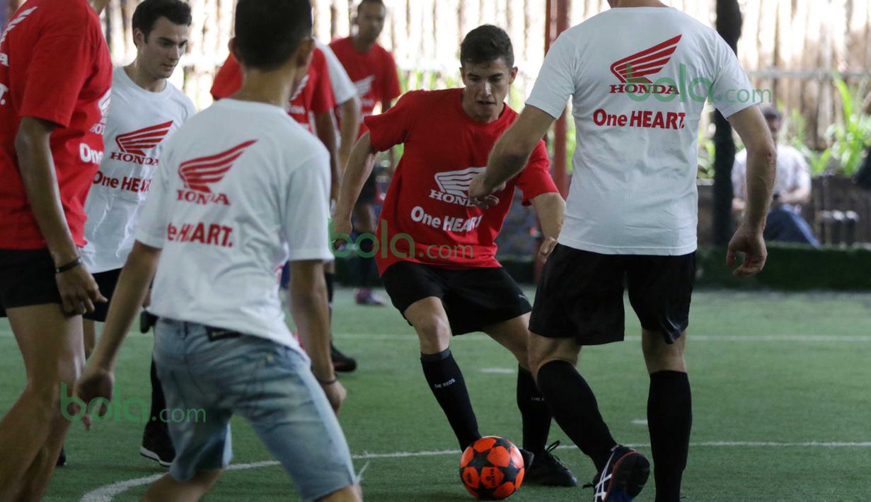 Marc Marquez (2kanan) mencoba melewati hadangan Dani Pedrosa (2kiri) dan tim Putih saat bermain futsal di Lapangan Futsal Kuningan Village, Jakarta, Sabtu (13/2/2016). (Bola.com/Nicklas Hanoatubun)