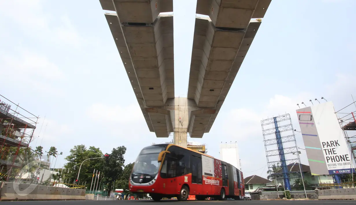 Bus Transjakarta melintas di bawah proyek Jalan Layang Non-Tol (JLNT) Busway Tendean-Ciledug di Kebayoran Baru, Jakarta, Minggu (13/3/2016). Proyek JLNT tersebut sudah mencapai 60 persen dan ditargetkan selesai 2016 ini. (Liputan6.com/Immanuel Antonius)
