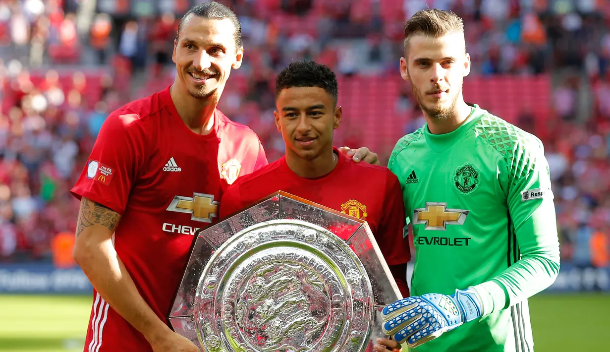 Zlatan Ibrahimovic, Jesse Lingard dan David De Gea berfoto bersama dengan Piala Community Shield di stadion Wembley, London, Inggris, (1/8). Gol Ibrahimovic menit ke 83 menjadi penentu kemengangan MU atas Leicester City. (Reuters/Andrew Couldridge)
