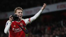 Pemain Arsenal, Martin Odegaard mengarahkan pose saat merayakan kemenangan setelah laga lanjutan Liga Inggris 2023/2024 melawan Liverpool di Emirates Stadium, London, Inggris, Minggu (05/02/2024) WIB. (AFP/Ian Kington)
