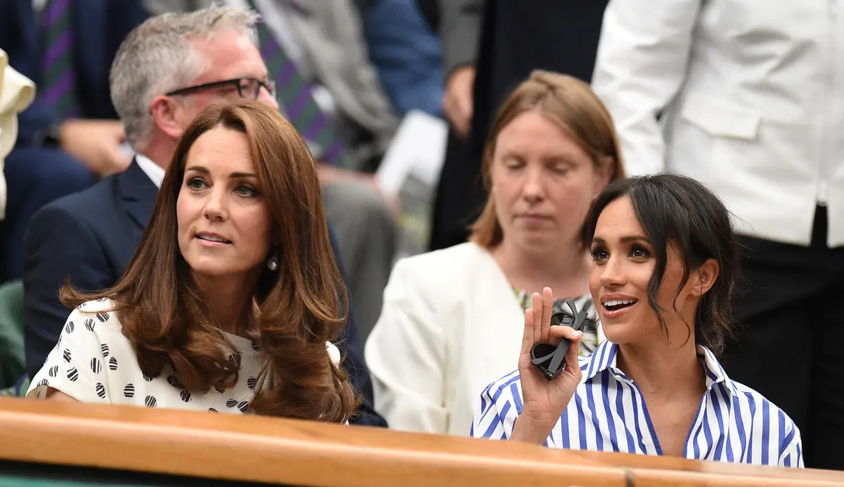 Kate Middleton dan Meghan Markle terlihat akrab dan banyak tertawa selama pertandingan tenis berlangsung. (OLI SCARFF / AFP)