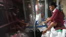 Usaha rumahan yang dirintis sejak tahun 1983 ini dipasarkan dengan harga bervariasi, mulai dari Rp10 ribu hingga Rp 300 ribu. Tampak dalam foto, pekerja menyelesaikan pembuatan keripik tempe di rumah usaha Keripik Tempe Mama Tina, Kebayoran Baru, Jakarta Selatan, Kamis (7/5/2026). (merdeka.com/Arie Basuki)