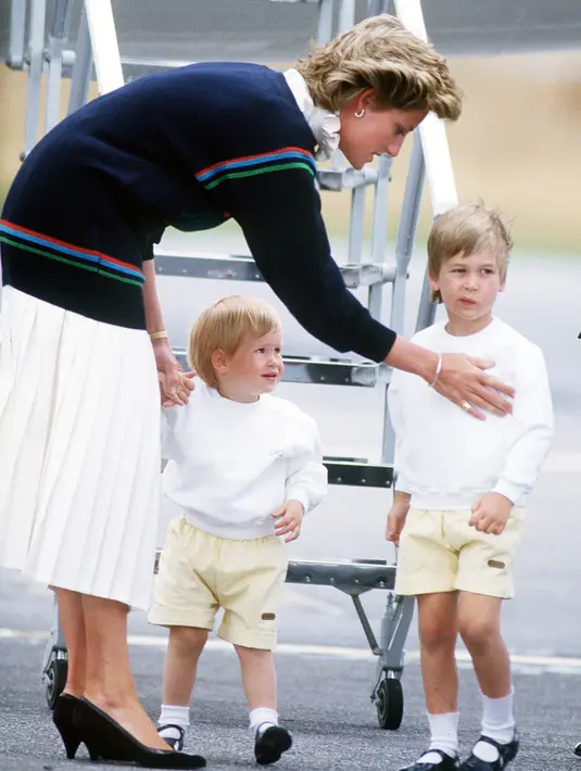 Dengan outfit senada, ini saat Pangeran William dan Harry di airport bersama dengan Puteri Diana pada Agustun 1986. (Jayne Fincher/Getty Images/USMagazine)