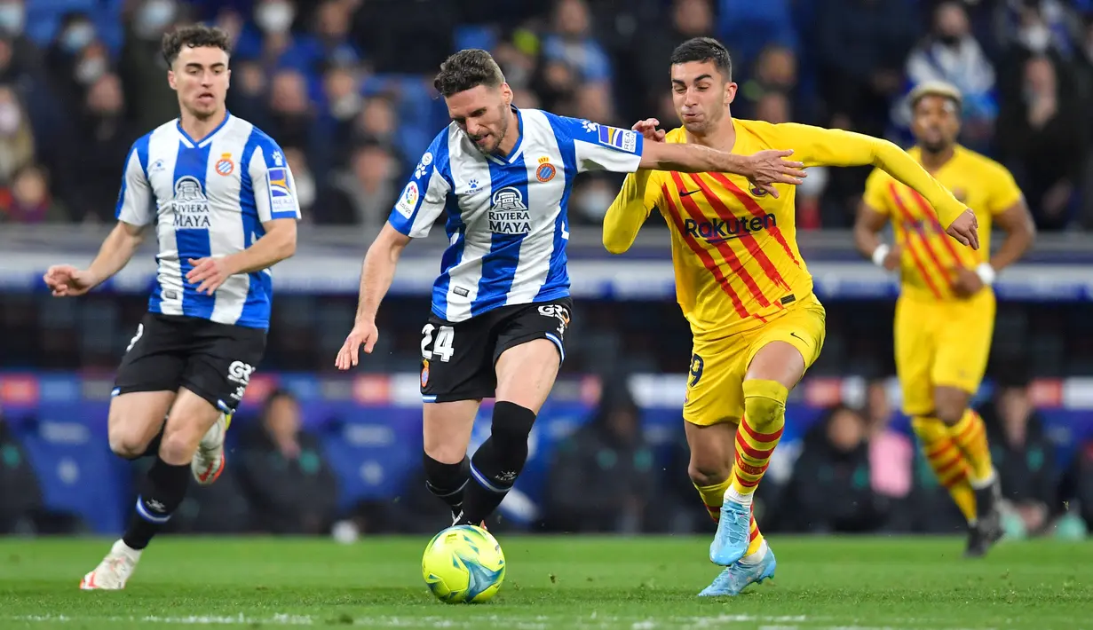 Bek Espanyol Sergi Gomez (kiri) berebut bola dengan pemain depan Barcelona Ferran Torres pada jornada ke-24 Liga Spanyol 2021/22 di RCDE Stadium, Senin dini hari WIB (14/2/2022). Espanyol dan Barcelona bermain imbang 2-2. (Pau BARRENA / AFP)