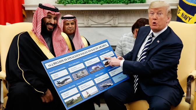 Presiden AS Donald Trump memegang informasi perlengkapan militer AS yang dijual kepada Arab Saudi dalam pertemuan dengan Putra Mahkota Mohammed bin Salman di Gedung Putih, Washington, Selasa (20/3). (AP Photo/Evan Vucci)