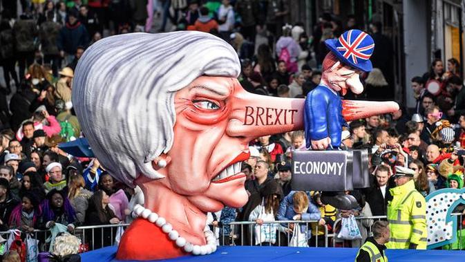 Karakter yang menggambarkan Perdana Menteri Inggris Theresa May dengan hidung panjang bertulis 'brexit' memeriahkan Karnaval Rose Monday di Duesseldorf, Jerman, Senin (4/3). (AP Photo/MartinMeissner)
