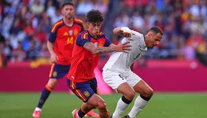 Marc Bernal dan Ali Al-Hamadi berduel memperebutkan bola dalam laga uji coba internasional antara Spanyol vs Irak di Estadio Abanca-Riazor, 5 Juni 2026. (AP Photo/Manu Fernandez)