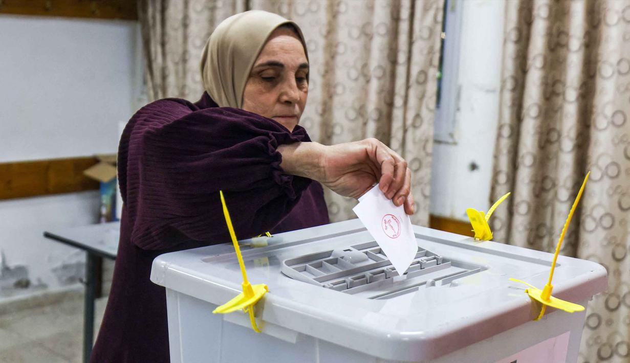 Sebagai informasi, Pemilu digelar bersamaan dengan upaya Israel untuk mendaftarkan lahan di Tepi Barat sebagai properti negara, sebuah kebijakan yang dikecam secara internasional sebagai aneksasi de facto. Tampak dalam foto, seorang perempuan Palestina memberikan suara di tempat pemungutan suara selama pemilihan kota di desa al-Badhan, utara Nablus, Tepi Barat yang diduduki Israel pada Sabtu 25 April 2026. (JAAFAR ASHTIYEH/AFP)