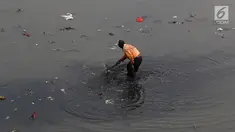 Petugas membersihkan sampah yang mengendap di Kanal Banjir Timur, Jakarta, Selasa (19/9). Diperkirakan sungai itu tercemar limbah sehingga airnya berwarna hitam pekat dan mengeluarkan bau tak sedap serta berbusa. (Liputan6.com/Immanuel Antonius)