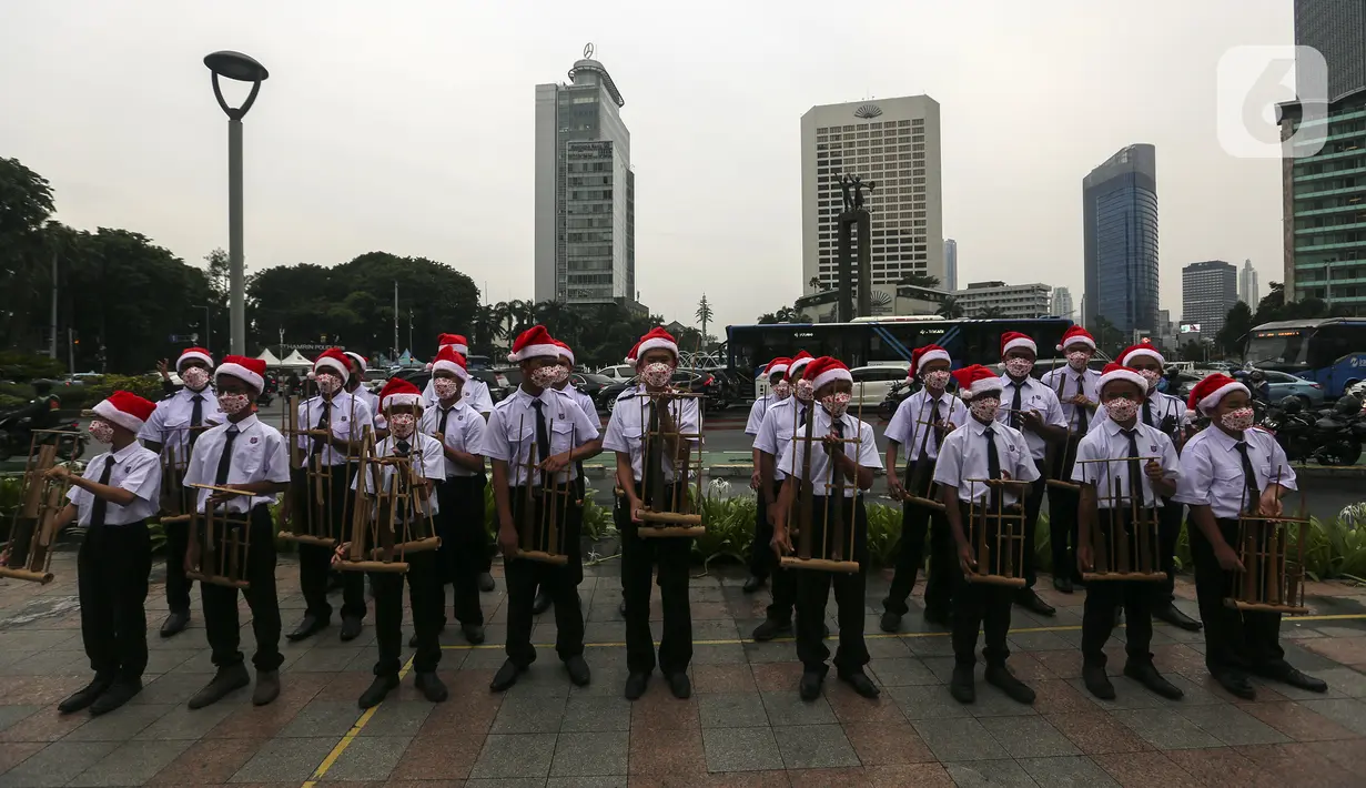 Para peserta bermain angklung saat acara Christmas in Jakarta di Bundaran Hotel Indonesia, Jakarta, Selasa (21/12/2021). Pemerintah Provinsi DKI Jakarta menggelar Christmas in Jakarta dalam rangka menyambut Natal 2021. (Liputan6.com/Johan Tallo)