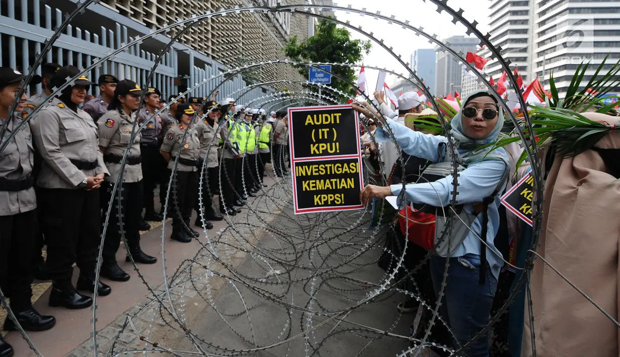 Petugas kepolisian berjaga saat aksi damai di depan gedung Bawaslu, Jakarta, Jumat (10/5/2019). Pada aksinya mereka melaporkan kecurangan pemilu yang merugikan pasangan Capres dan Cawapres nomor urut 02 dan menuntut Bawaslu untuk tetap netral. (Liputan6.com/Herman Zakharia)