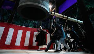 Orang-orang membunyikan lonceng raksasa untuk merayakan Tahun Baru beberapa menit setelah tengah malam di Kuil Buddha Zojoji, Tokyo, Jepang, Senin (1/1/2024). (AP Photo/Eugene Hoshiko)