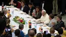 Paus Fransiskus duduk di sebuah meja dalam jamuan makan siang di Aula Paul VI, Vatikan, Minggu (17/11/2019). Paus Fransiskus mengundang sekitar 1.500 orang miskin, tunawisma, imigran dan pengangguran untuk makan siang dalam memperingati Hari Orang Miskin Sedunia. (AP/Alessandra Tarantino)