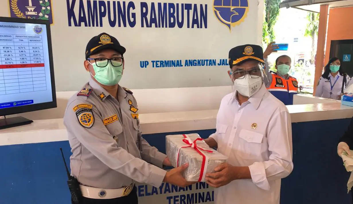 Menteri Perhubungan Budi Karya Sumadi (kanan) menyerahkan masker di Terminal Kampung Rambutan, Jakarta, Kamis (29/10/2020). Budi Karya melakukan edukasi kepada penumpang yang masih banyak menggunakan masker scuba untuk memakai masker medicated atau berlapis. (Dok: Kemenhub)