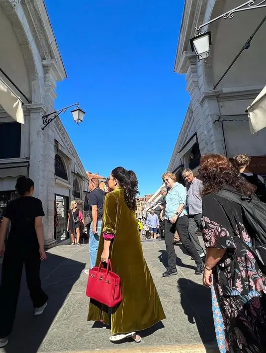 Istri Bambang Trihatmodjo ini juga tak segan tampil dengan padu padan outfit warna berani.