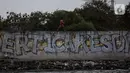 Seorang anak bermain di pelabuhan sunda kelapa, Jakarta, Kamis (12/8/2021). Kegiatan bermain dipinggir dan berenang air laut ini merupakan bagian dari keseharian mereka mengisi waktu kosong diluar jam sekolah. (Liputan6.com/Johan Tallo)