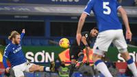 Gelandang Manchester City, Ruyad Mahrez (tengah) melakukan sepakan melengkung yang berujung gol untuk timnya ke gawang Everton, pada laga lanjutan Liga Inggris, di stadion Goodison Park, Kamis (18/2/2021) dini hari WIB.  (AFP / Jon Super)