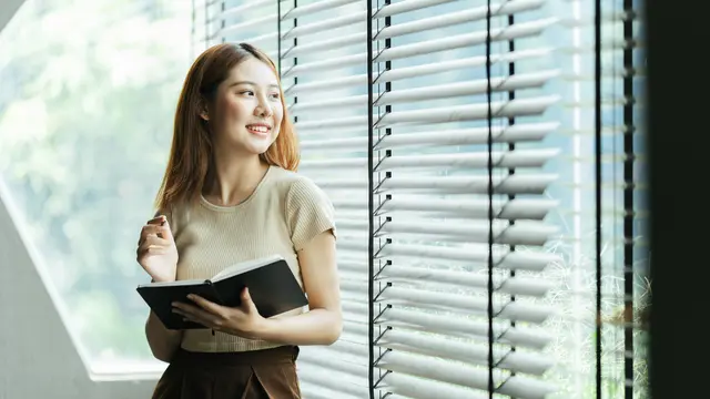 perempuan dan membawa buku