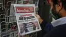 Seorang pria yang memakai masker membaca berita utama pemilihan presiden AS di stan surat kabar di Paris pada Rabu (4/11/2020). (AP Photo/Michel Euler)