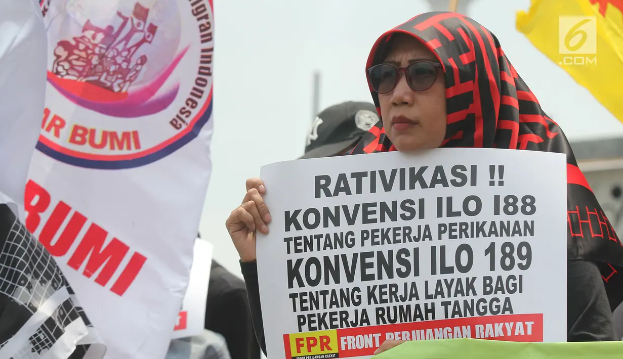 Massa yang tergabung dari berbagai elemen membawa poster saat melakukan aksi unjuk rasa memperingati Hari Buruh Migran Internasional 2018 di depan Istana Merdeka, Jakarta, Selasa (18/12). (Merdeka.com/Imam Buhori)