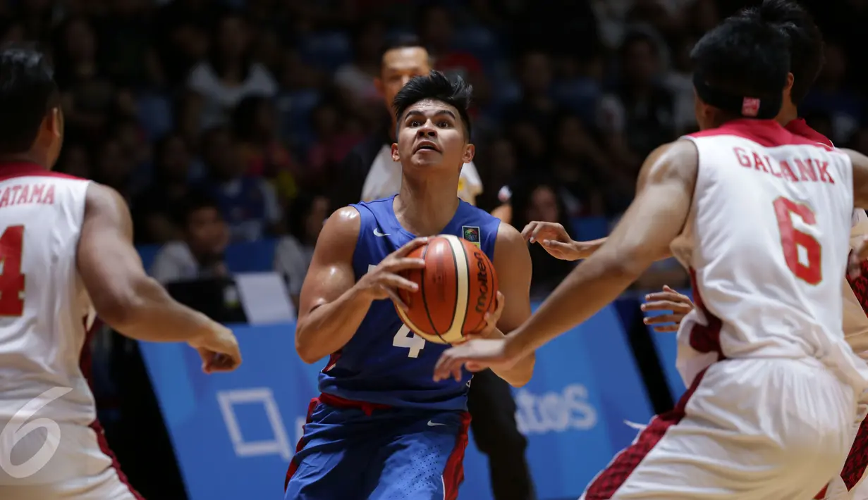 Dua pebasket Indonesia, Adhi Putra Pratama (kiri) dan Galank Gunawan berusaha menahan pemain Filipina, Kiefer Ravena dalam laga penyisihan Grup A SEA Games 2015 di OCBC Arena Hall, Singapura, Rabu (10/6/2015). (Liputan6.com/Helmi Fithriansyah)