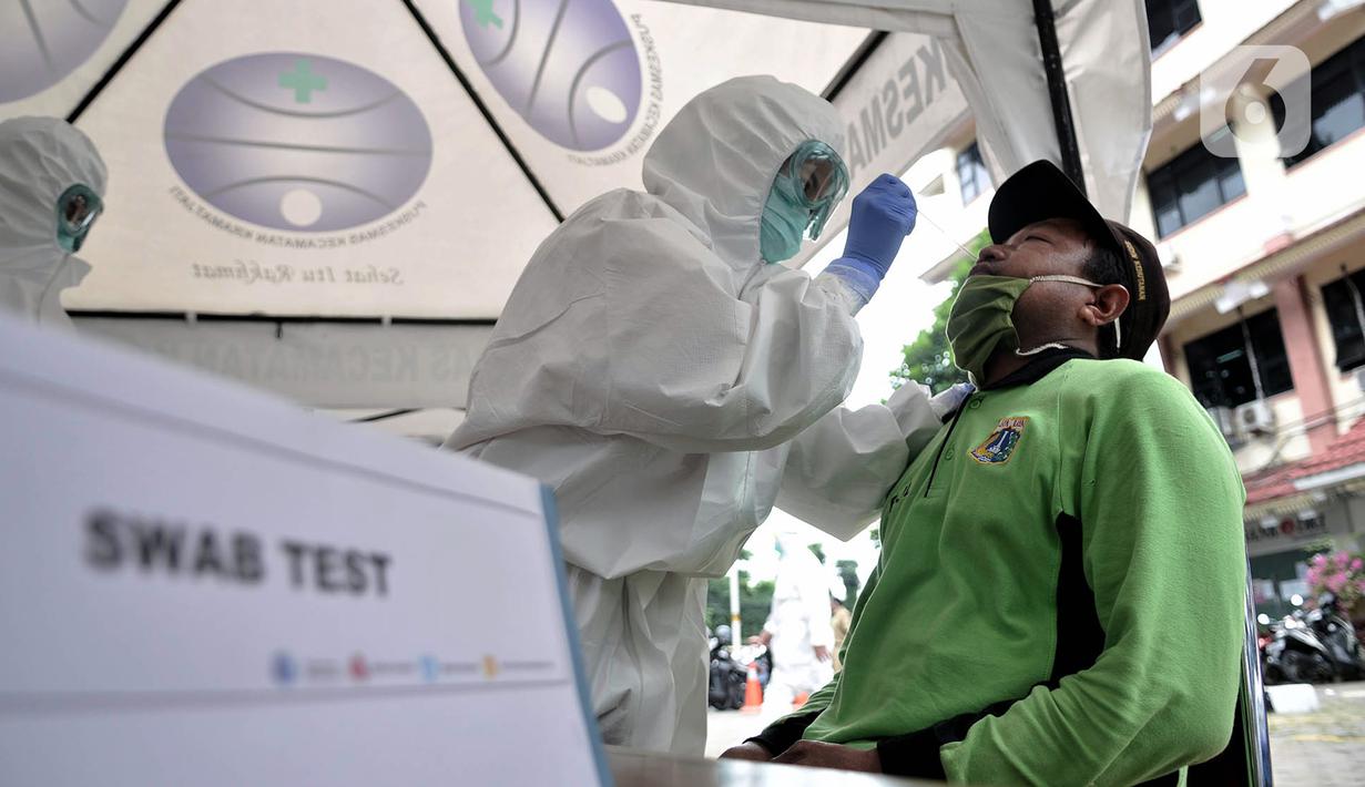 Petugas medis melakukan tes swab COVID-19 terhadap peserta di Kantor Kecamatan Kramat Jati, Jakarta, Selasa (16/6/2020). Puskesmas Kecamatan Kramat Jati menggelar tes swab bagi seluruh pegawai instansi pemerintahan untuk memutus rantai penyebaran COVID-19. (merdeka.com/Iqbal Nugroho)
