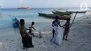 Beberapa anak membersihkan sampah plastik yang ada di bibir pantai Desa Sawandarek, Raja Ampat, Papua Barat, Jumat (22/11/2019). Aksi membersihkan sampah plastik ini, digagas Carrie, aktivis asal Amerika Serikat,  yang sudah menetap di Indonesia selama 3 tahun. (Liputan6.com/Herman Zakharia)