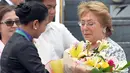 Presiden Chili Michelle Bachelet (kanan) diberikan karangan bunga saat tiba di bandara internasional  Manila, Filipina, (17/11/2015). Michelle Bachelet hadir untuk menghadiri Kerjasama Ekonomi Asia - Pasifik (APEC). (REUTERS/Ezra Acayan)