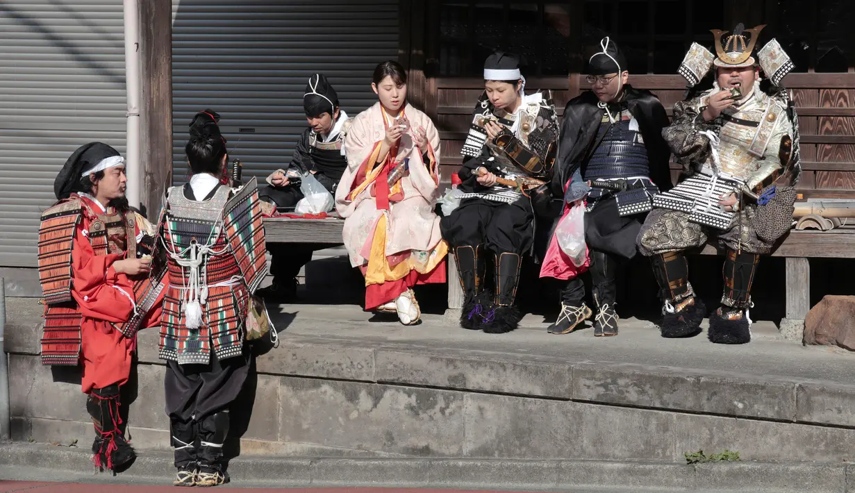 Pemandu Satoshi Kamakura dan peserta mengenakan pakaian tradisional Jepang Samurai saat mengikuti tur situs bersejarah di Kamakura, Jepang (26/11). (AP Photo/Shizuo Kambayashi)