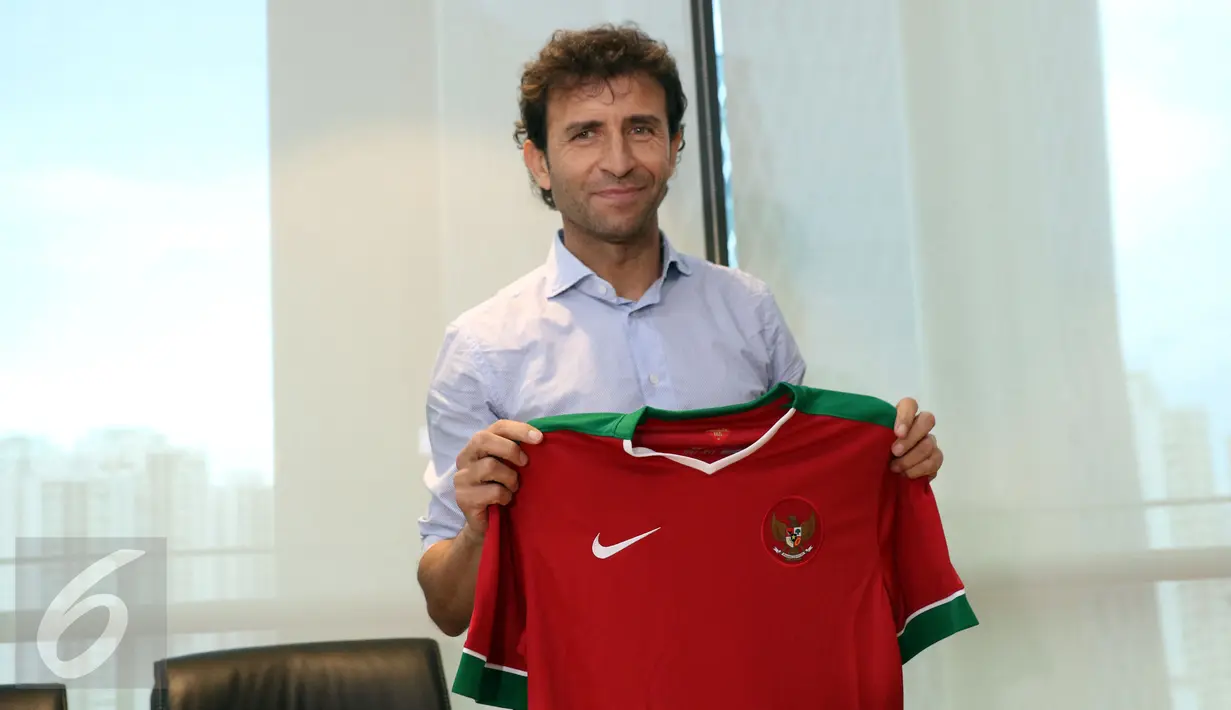 Pelatih asal Spanyol, Luis Milla Aspas berfoto dengan kaos Timnas Indonesia usai jumpa pers di kantor PSSI, Jakarta, Jumat (20/1). Luis Milla Aspas resmi menukangi Timnas Indonesia dengan durasi kontrak dua tahun. (Liputan6.com/Helmi Fithriansyah)
