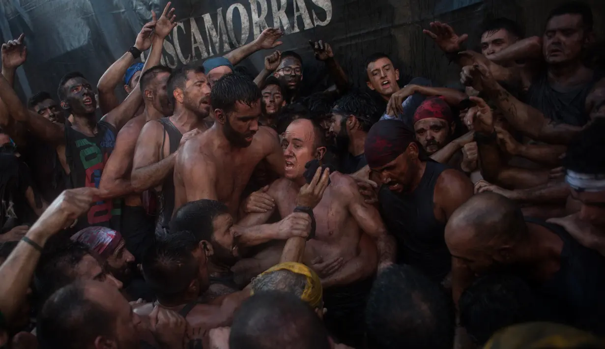 Peserta saling menyiram minyak hitam ke tubuh dan melemparkannya ke udara selama festival tradisional Cascamorras di Baza, Spanyol, Rabu (6/9). Pada 20016, festival ini dinyatakan sebagai Fiesta of National Tourist Interest of Spain. (JORGE GUERRERO/AFP)