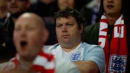 Seorang suporter saat menyaksikan pertandingan Inggris melawan Slovenia pada grup F kualifikasi Piala Dunia 2018 di stadion Wembley, London, (5/10). Inggris menang 1-0 atas Slovenia. (AFP Photo/Adrian Dennis)