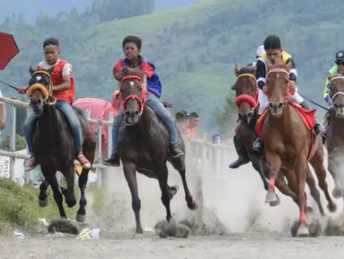 Sejumlah joki muda memacu kuda dalam lomba pacuan kuda tradisional di Takengon, Aceh, 10 Maret 2018. Budaya yang telah diwariskan turun temurun sejak zaman kolonial Belanda untuk merayakan musim panen tahunan. (AFP PHOTO/CHAIDEER MAHYUDDIN)