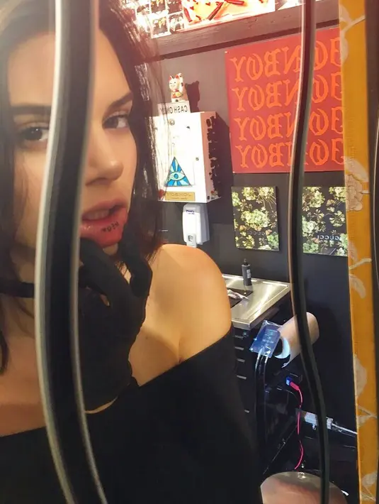 Kendall Jenner menuliskan kata "meow" secara permanen di balik bibir bawahnya. (instagram/jonboytattoo)