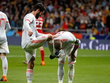 Kapten timnas Spanyol, Sergio Ramos mencium sepatu rekan setimnya Isco Alarcon usai mencetak gol kedua saat pertandingan persahabatan melawan Argentina di stadion Wanda Metropolitano di Madrid (27/3). (AP Photo / Paul White)