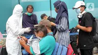 Petugas medis (kiri) melakukan rapid test antigen terhadap calon penumpang di Terminal 2 Bandara Soekarno-Hatta, Tangerang, Banten, Selasa (22/12/2020). Calon penumpang mengaku rata-rata antre hingga tiga jam untuk mendapatkan layanan rapid test antigen. (merdeka.com/Arie Basuki)