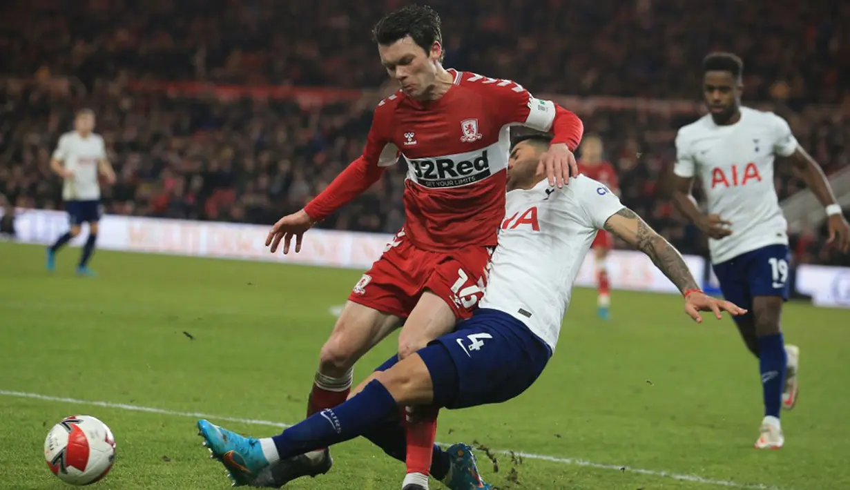 Pemain Tottenham Hotspur Cristian Romero (tengah) berebut bola dengan pemain Middlesbrough Jonny Howson pada pertandingan putaran kelima Piala FA di Stadion Riverside, Middlesbrough, Inggris, 1 Maret 2022. Tottenham Hotspur kalah 1-0 dan tersingkir dari Piala FA. (Lindsey Parnaby/AFP)