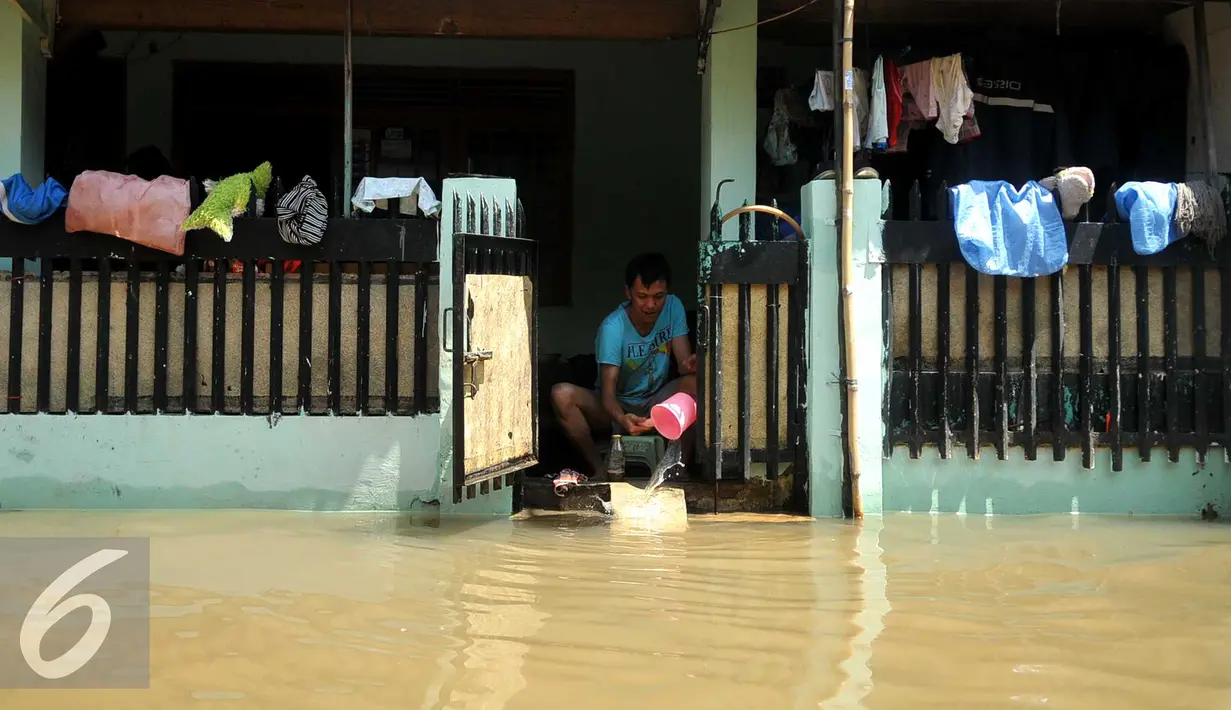 Seorang warga saat menguras air akibat banjir di komplek Polri jalan Pondok Karya, Mampang, Jakarta, Kamis (21/4). Banjir setinggi 120cm disebabkan meluapnya Kali Mampang. (Liputan6.com/Gempur M Surya)