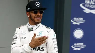 Pembalap Mercedes F1 Lewis Hamilton tersenyum usai kualifikasi di Australian Formula One Grand Prix di Melbourne (19/3). Lewis Hamilton menjadi yang tercepat pada sesi kualifikasi Formula 1 2016 di Sirkuit Albert Park. (REUTERS/Jason Reed)