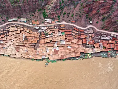 Foto udara menunjukkan tambak garam di Kecamatan Naxi, Prefektur Qamdo, Daerah Otonom Tibet, China, 28 September 2020. Warga menggunakan metode memanen garam tradisional dengan mengumpulkan air asin dari kolam dan tambang garam, lalu menguapkannya hingga terjadi pengkristalan. (Xinhua/Zhan Yan)