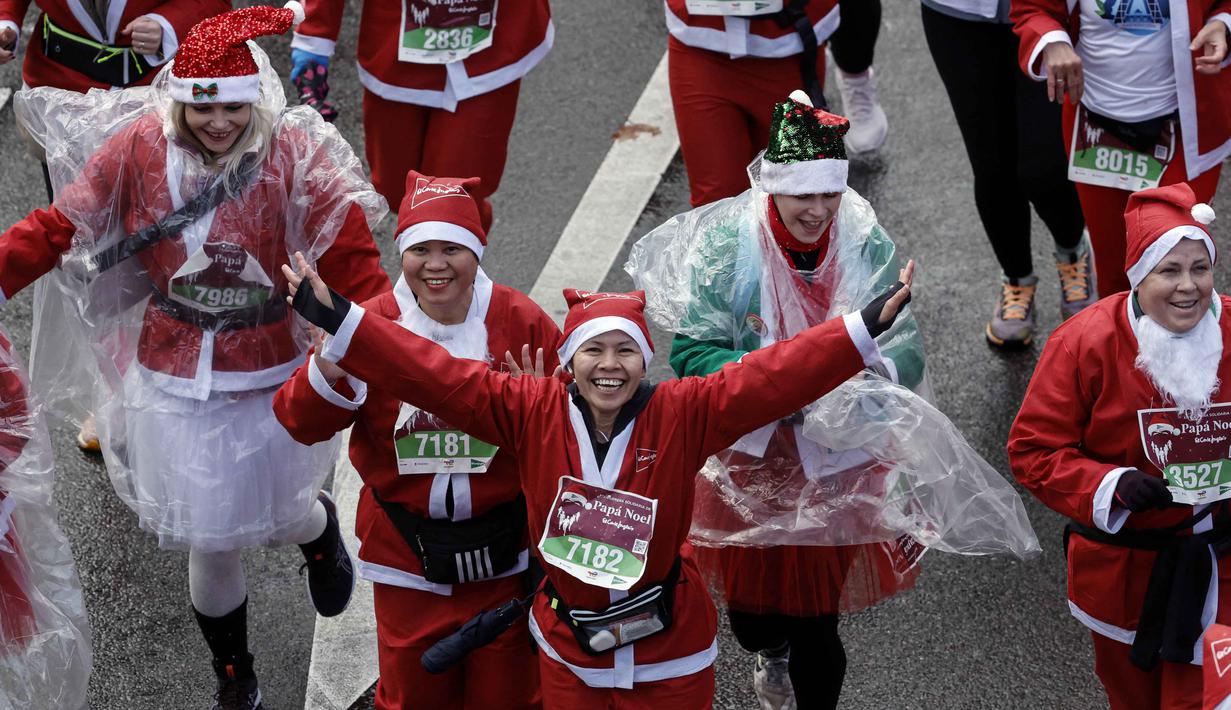 Tujuan kegiatan ini adalah untuk mengumpulkan dana amal dan merayakan Natal bersama dengan membagikan kebaikan. Tampak dalam foto, ribuan pelari yang mengenakan kostum Santa Claus berpartisipasi dalam edisi ke-14 lomba Santa Claus, sebuah lari santai sejauh 4,5 km melalui jalan-jalan Madrid pada Minggu 21 Desember 2025. (OSCAR DEL POZO/AFP)