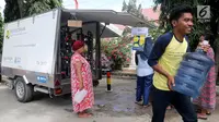 Pengungsi korban gempa dan tsunami Palu membawa galon usai mengisi air dari mobil instalasi pengolahan air Kementerian Pekerjaan Umum dan Perumahan Rakyat (PUPR) di halaman kantor Wali Kota Palu, Sulawesi Tengah, Senin (8/10). (Liputan6.com/Fery Pradolo)