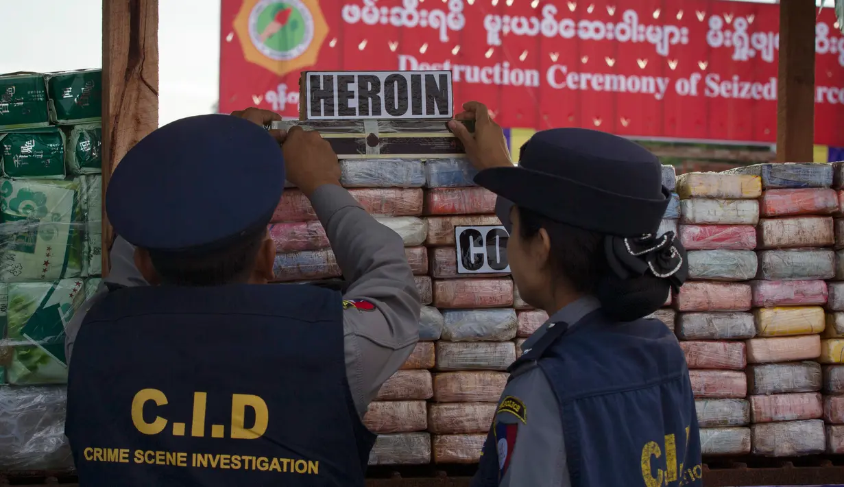 Aparat kepolisian Myanmar memeriksa narkotika sitaan sebelum acara pemusnahan pada Hari Antinarkoba Sedunia, di Yangon, Senin (26/6). Myanmar membakar opium, heroin, dan kokain senilai sekitar US$385 juta, setara Rp5,1 miliar. (AP Photo/Thein Zaw)