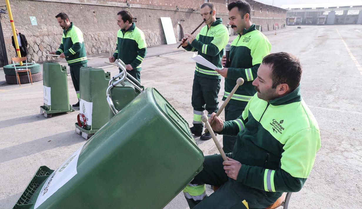 Anggota "Grup Tin" yang bekerja sebagai petugas kebersihan kota memperlihatkan keahlianya bermain musik dengan menggunakan tempat sampah dan barang bekas di distrik Cankaya, Ankara, Turki (9/1). (AFP Photo/Adem Altan)