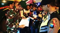 Sebanyak 26 orang penumpang bus asal Sumba Barat, Nusa Tenggara Timur (NTT) diamankan aparat Kepolisian, Minggu malam (19/5/2019). (Liputan6.com/ Dian Kurniawan)