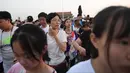 Warga berjalan menghadiri upacara pengibaran bendera saat fajar setelah kematian mantan perdana menteri China Li Peng di Lapangan Tiananmen Beijing (24/7/2019). Li Peng meninggal dunia akibat menderita kanker kandung kemih. (AFP Photo/Greg Baker)